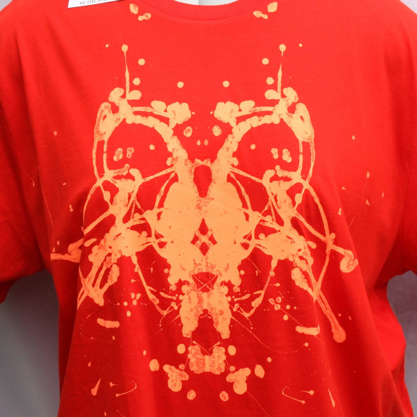 close up of Rorschach, Red cotton T-Shirt with Fluorescent Orange ink blot - 3XL #1 (RR FlO 3XL1) under dayloght