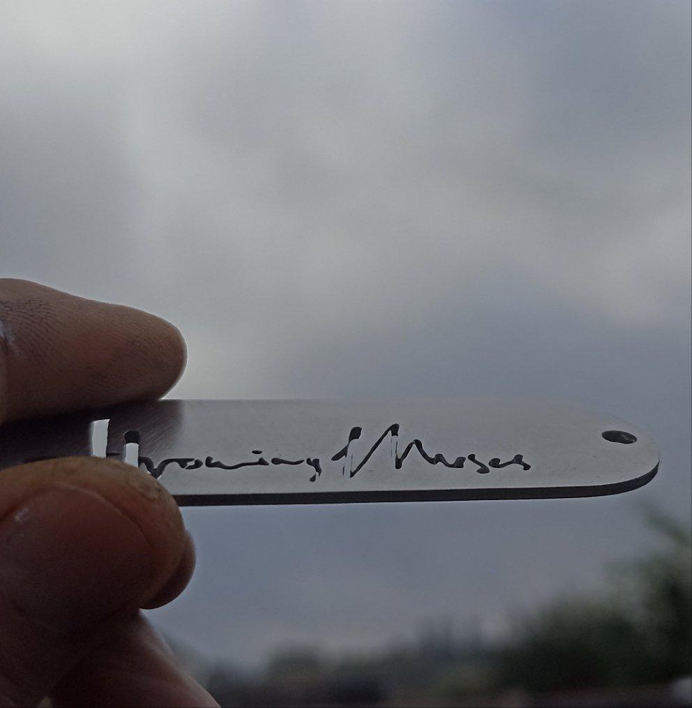 Angled view of the Throwing Muses logo keyring, showing off the CNC detailing and sleek stainless steel shine, crafted for durability and style.