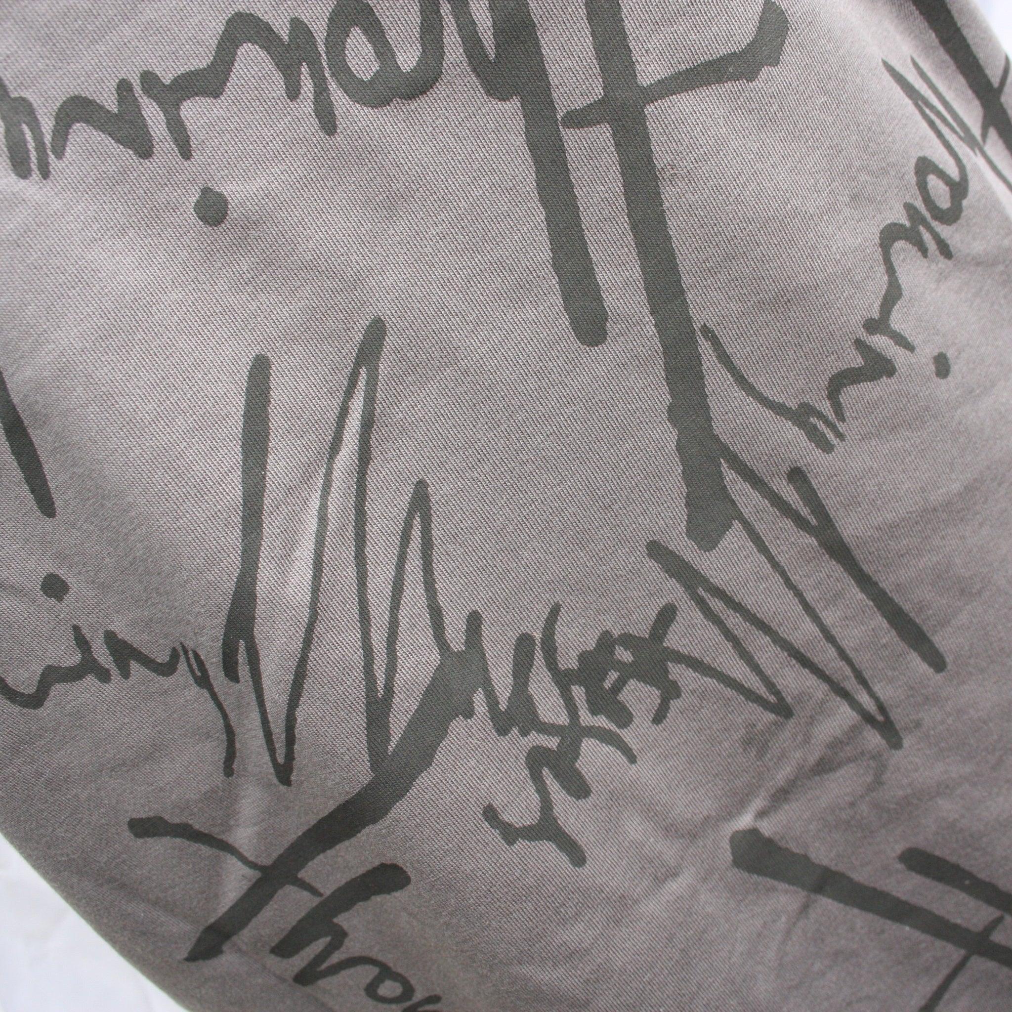 Close-up of black Throwing Muses logo on charcoal fabric ��� unique messy print effect, hand-printed.