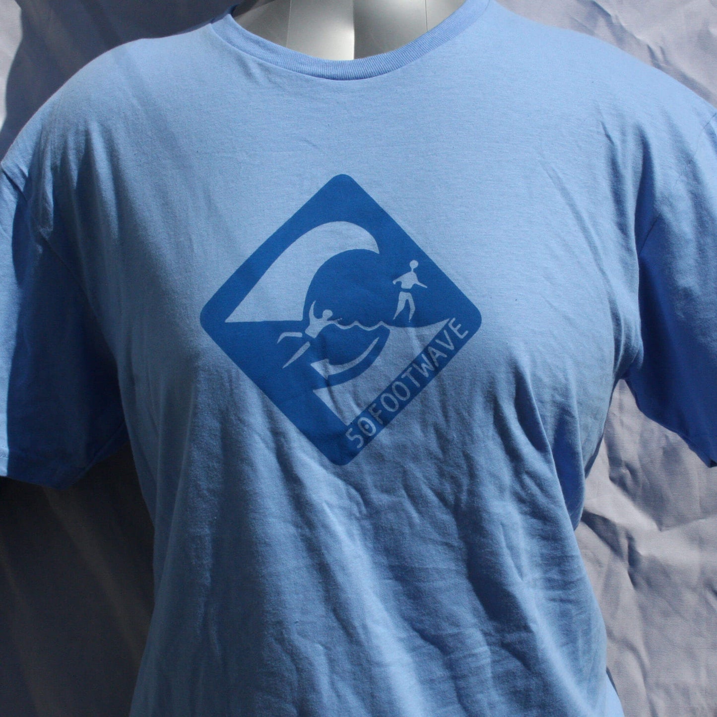 50 Foot Wave logo t-shirt, hand screen-printed in vibrant blue on a Carolina Blue, 100% cotton Gildan Softstyle fabric, designed by ElRatDesigns