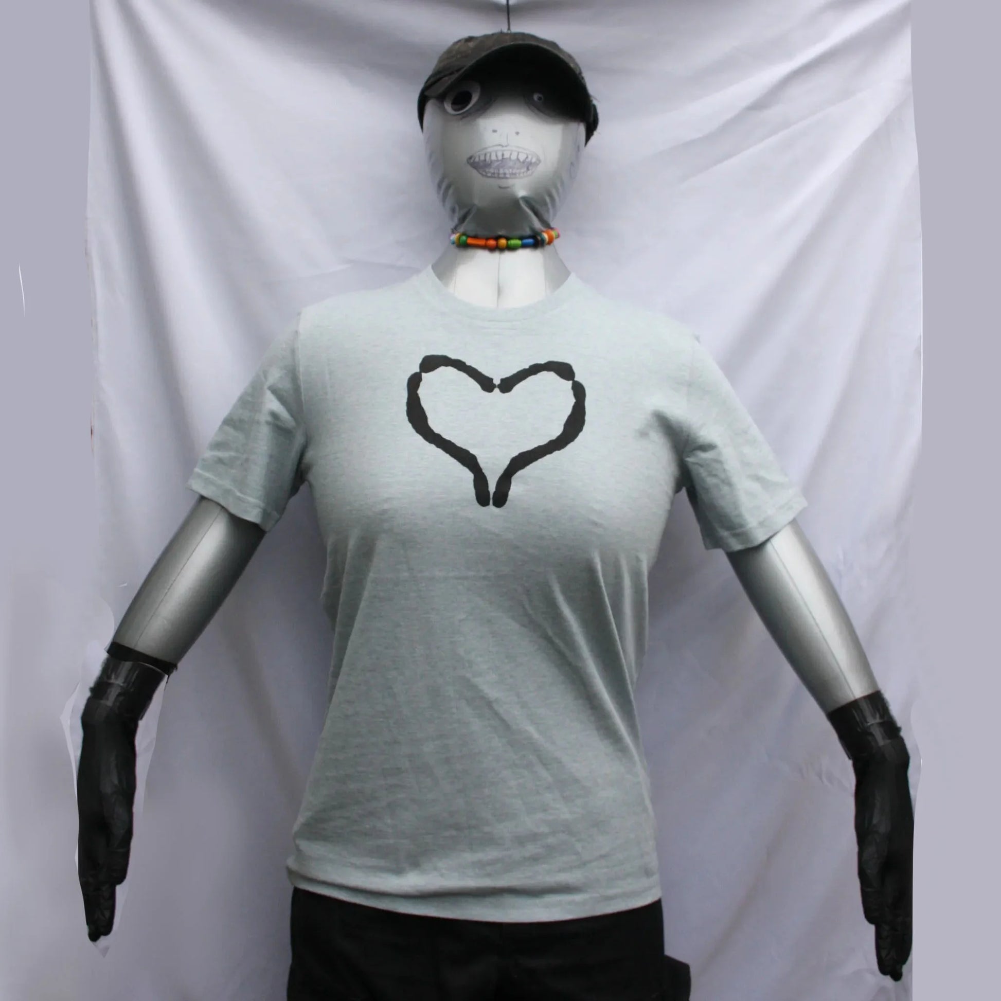 Mae Rose Owens wearing a Blue/Grey t-shirt with a black heart design, by ElRat Designs