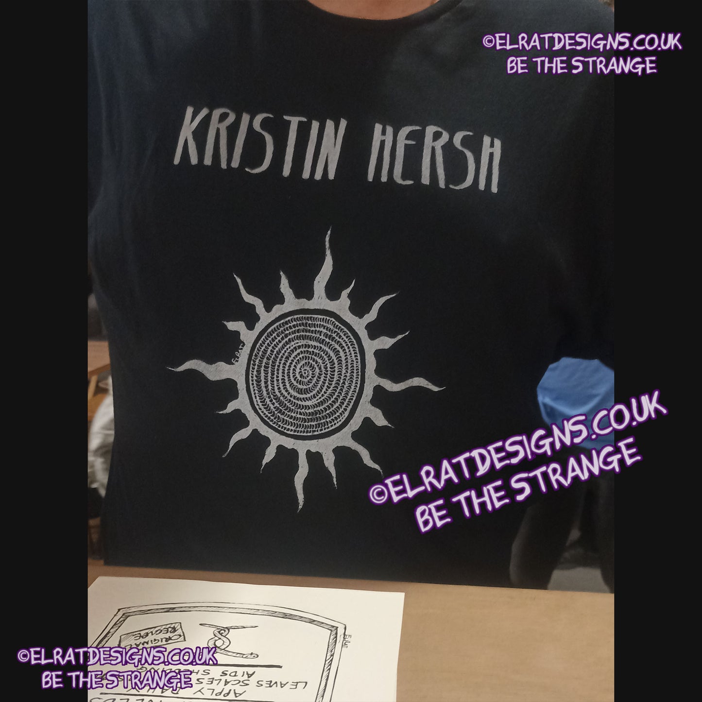 ElRat in the Wild - seen at the Throwing Muses show in Manchester 2025 - Kristin Hersh, Silver Sun, ElRat hand drawn Spiral sun printed in Silver, Back Print "How much for a life you don't despise?". hand pulled screen print with eco friendly water based ink. only from elratdesigns.co.uk - hero